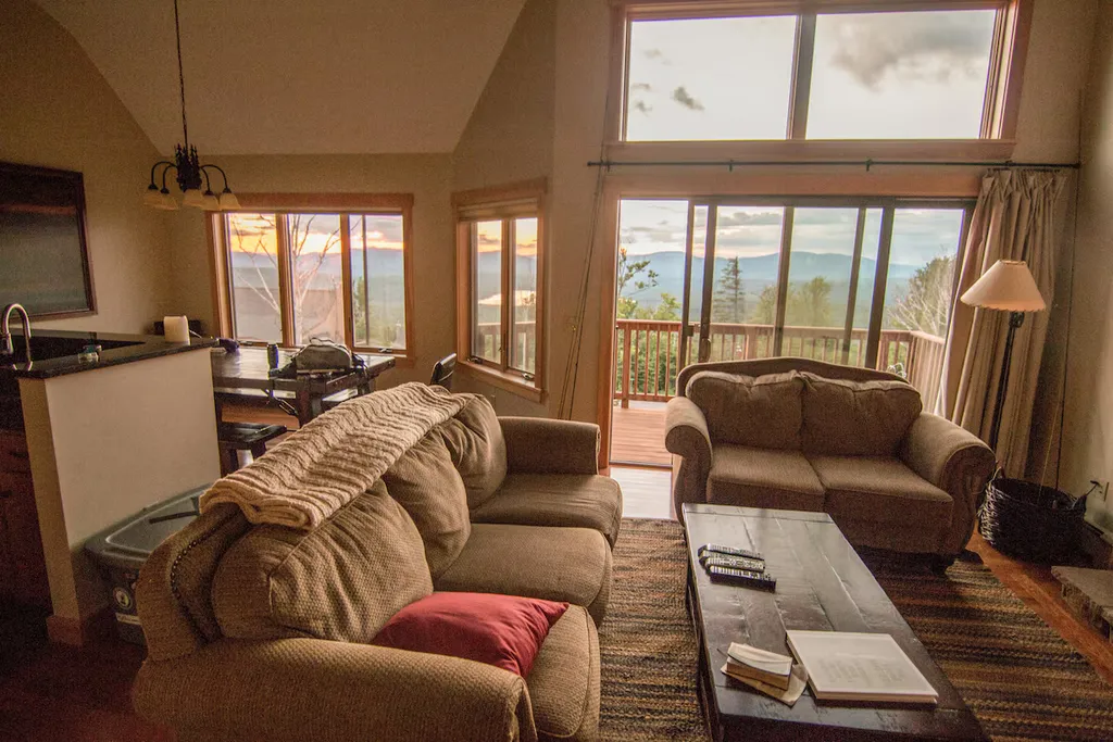 Living room with couches, coffee table, and a view of mountains.